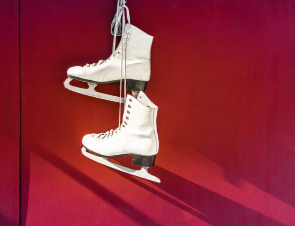 hanged pair of white leather figure skates