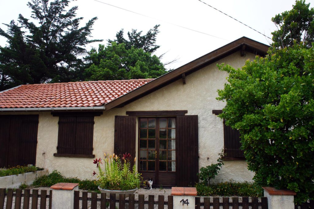 Haus in Lacanau, vor dem eine Katze sitzt